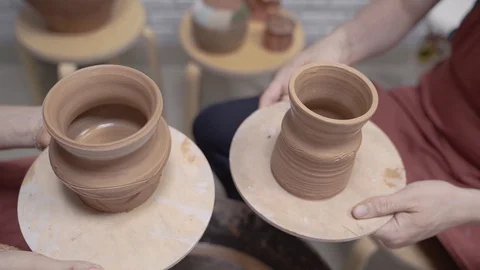 A close-up view of the hands of a man and woman sculpting clay. Stock Footage 128577622