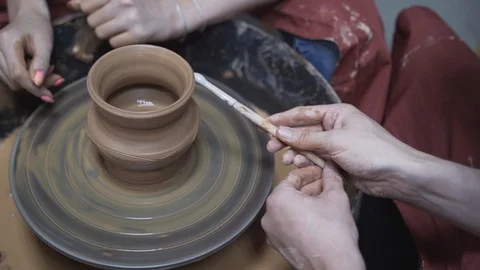 A close-up view of the hands of a man and woman sculpting clay. Stock Footage 128577626