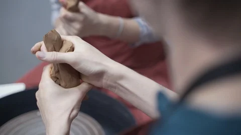 A close-up view of the hands of a man and woman sculpting clay. Stock Footage 128577648