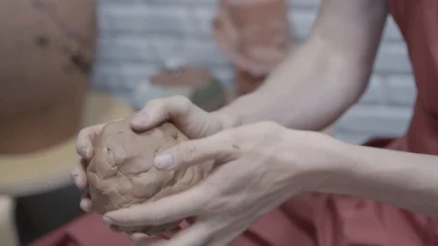 A close-up view of the hands of a man and woman sculpting clay. Stock Footage 128577707