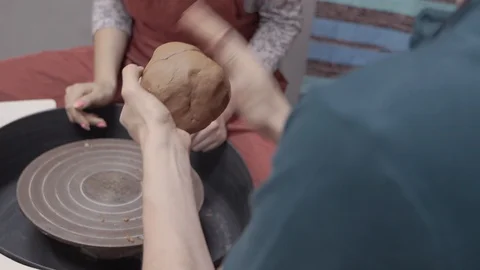 A close-up view of the hands of a man and woman sculpting clay. Stock Footage 128577714