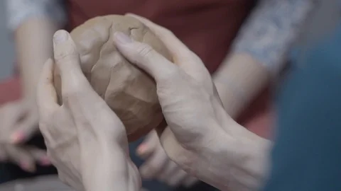 A close-up view of the hands of a man and woman sculpting clay . Stock Footage 128577742
