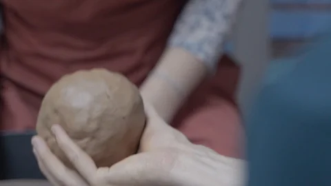 A close-up view of the hands of a man and woman sculpting clay. Stock Footage 128577762