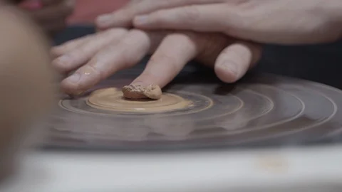 A close-up view of the hands of a man and woman sculpting clay. Stock Footage 128577775