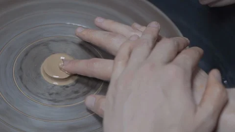 A close-up view of the hands of a man and woman sculpting clay. Stock Footage 128577802