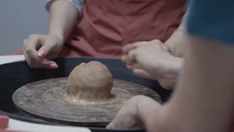 A close-up view of the hands of a man and woman sculpting clay. Stock Footage 128577850