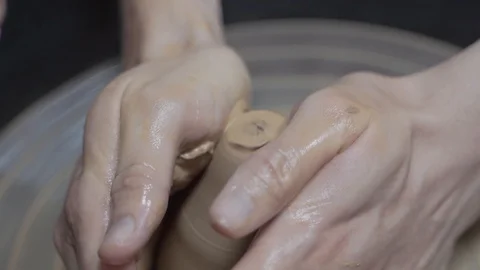 A close-up view of the hands of a man and woman sculpting clay. Stock Footage 128577870
