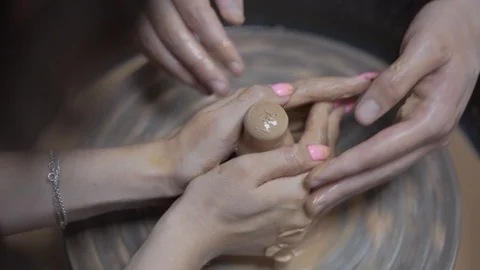 A close-up view of the hands of a man and woman sculpting clay . Stock Footage 128577887