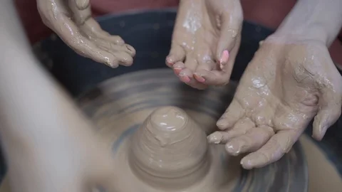 A close-up view of the hands of a man and woman sculpting clay. Stock Footage 128577893