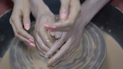 A close-up view of the hands of a man and woman sculpting clay. Stock Footage 128577916