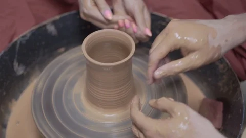 A close-up view of the hands of a man and woman sculpting clay . Stock Footage 128577945
