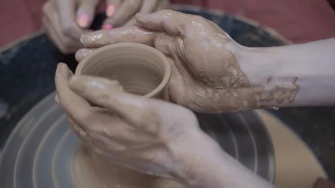 A close-up view of the hands of a man and woman sculpting clay. Stock Footage 128577955