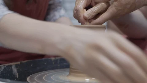 A close-up view of the hands of a man and woman sculpting clay. Stock Footage 128578029
