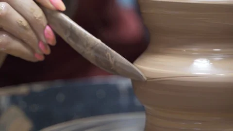 A close-up view of the hands of a man and woman sculpting clay. Stock Footage 128578069