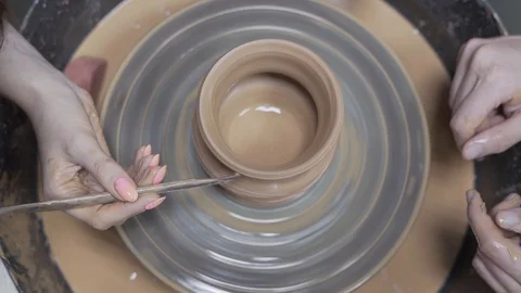 A close-up view of the hands of a man and woman sculpting clay. Stock Footage 128578070