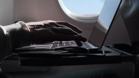 Close up view of hands man typing text on computer, flying in airplane. During Stock Footage 168971722