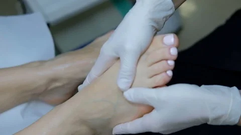 Close-up view on hands of masseuse making foot rubdown to woman. Stock Footage 78122251