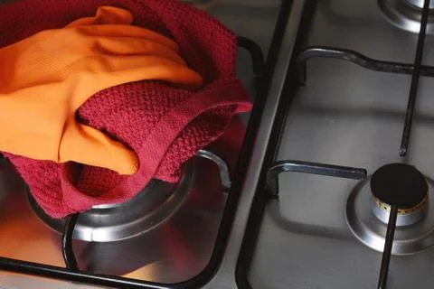 Close up view of hands in rubber gloves cleaning hob Stock Photos
