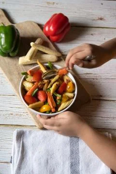 Close up view of hands serving saute vegetables Stock Photos