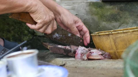 Close up view on hands slicing fish on a wooden board in the dirty outdoor Stock Footage 136279906