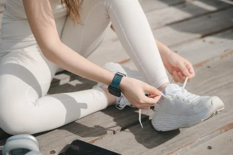 Close up view of hands tying white sneaker for running and jogging while si.. Stock Photos