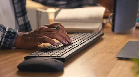 Close-up view of hands typing on a black computer keyboard. Office or home .. 写真素材