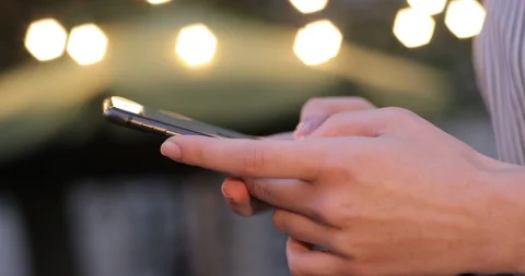 Close-up view of hands typing on the cell phone with the lights on the Stock Footage 104620135