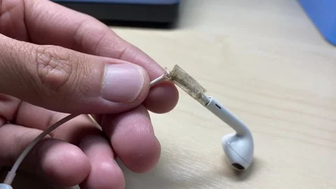 Close up view hands use adhesive sticky tape fix broken white headphones cable Stock Footage 248664424