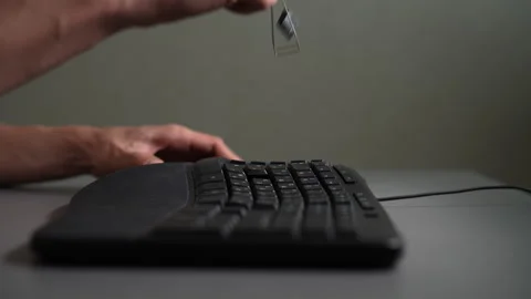 Close-up view of hands using special tool to remove keycap from black computer Stockbeeldmateriaal 342764474
