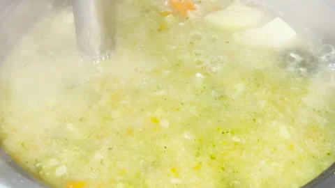A close up view of hands whipping pureed soup with a blender and pureeing Stock Footage 281455859