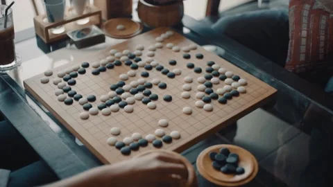 Close up view of hands young people playing go board game in living room	 Stock Footage 133444874