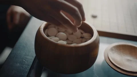 Close up view of hands young people playing go board game in living room	 Stock-Footage 134057803