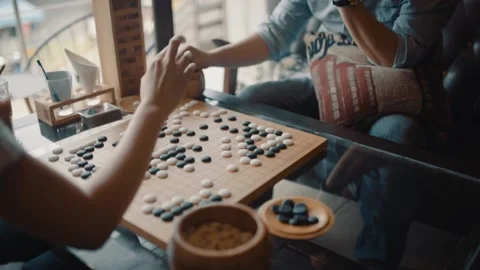 Close up view of hands young people playing go board game in living room Stock Footage 134057925