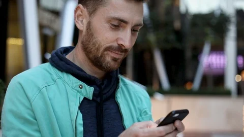 Close up view of Handsome Bearded Young Man. Typing a Message on his Mobile Stock Footage 92439257