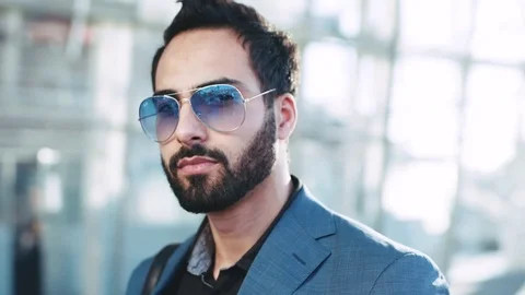 Close up view of handsome man of Eastern appearance in sunglasses and stylish Stock Footage 76744579