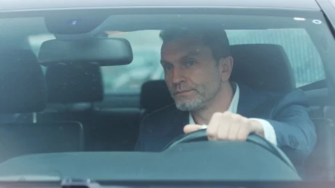 Close up view of handsome man in luxurious car impatiently beeping car horn Stock Footage 105256173
