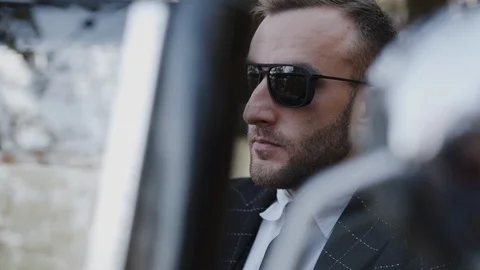 Close view of handsome man in sunglasses sitting in retro car Video stock 124731381