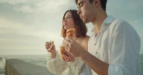 Close up view of a happy cheerful brunette girl in a white dress eating Stock Footage 283834662