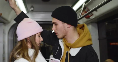 Close up view of happy guy and girl listening to music and dancing while going Stock Footage 136485265