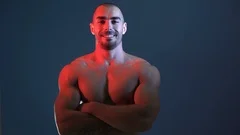 Shirtless young man flexing chest muscle, Stock Video
