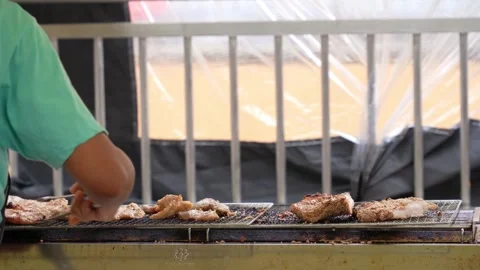 Close-up view of the hawker grilling the pork necks. 動画素材 240887039