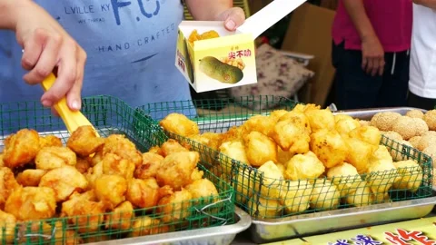 Close-up view of the hawker selling various types of deep fried food 動画素材 214544417