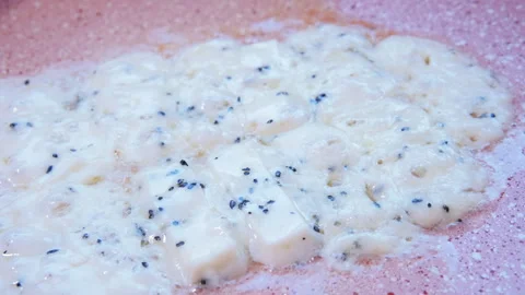 Close-up view of herb cheese melting in a sizzling frying pan Видео 280471372