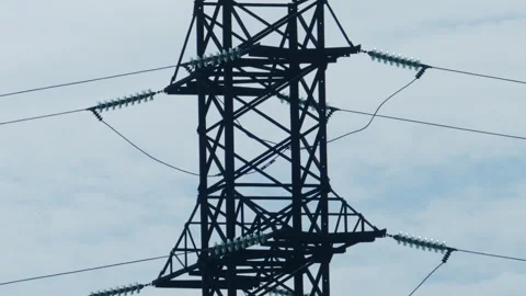 Close up view of a high voltage electricity transmission tower and power lines Stock Footage 336869751