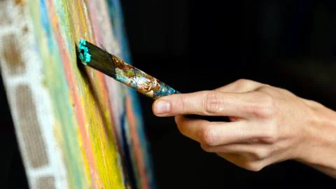 Close-up view of highly gifted painter while he is painting his picture. Фото