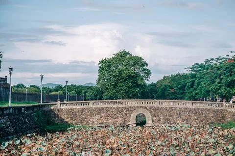 Close view of a historic stone arch opening through a citadel wall with lotus Stock Photos