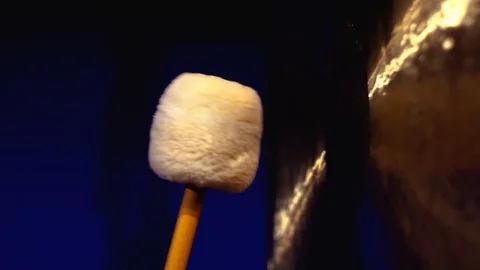 Close-up view of hitting a big gong with in a dark room.  Stock Footage 100561174