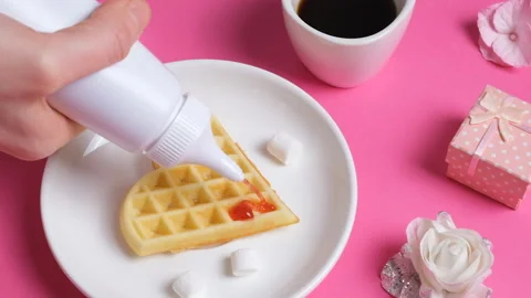 Close up view on home made heart-shaped waffle topped with strawberry syrup, a Stock-Footage 169662495