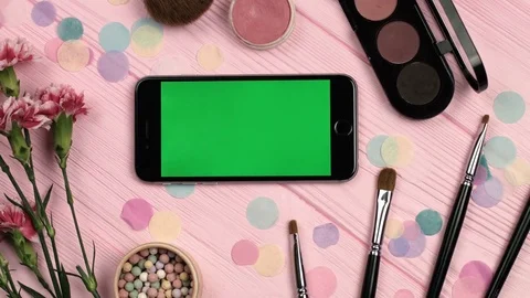 Close up view of horizontal mobile phone with green screen on pink wooden table Stock Footage 73910879