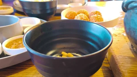 Close-up view of hot rich steaming tomato soup being poured into a black empty b Video stock 318260727